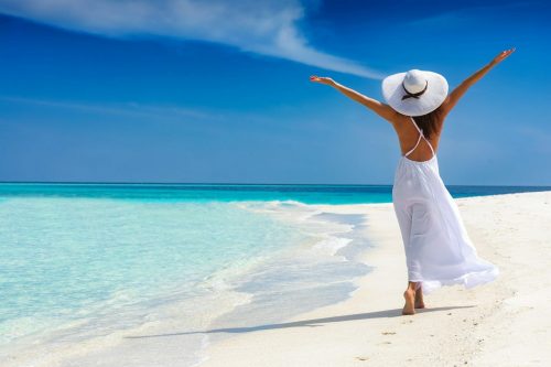 Happy,Traveller,Woman,In,White,Dress,Enjoys,Her,Tropical,Beach